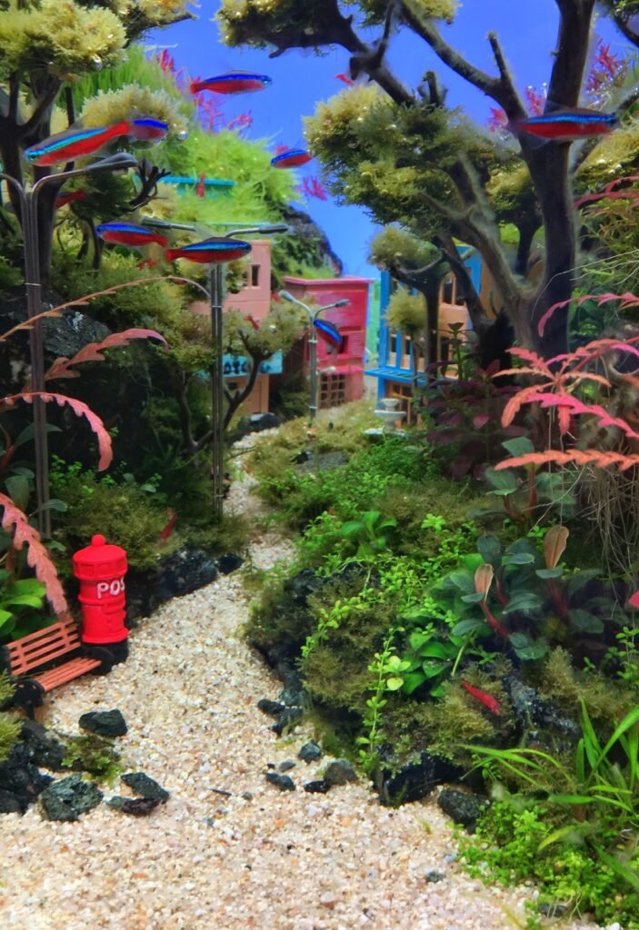 Aquascape fantaisie du Fishtival 2025 : paysage urbain miniature peuplé de figurines, photo Frédéric Fasquel