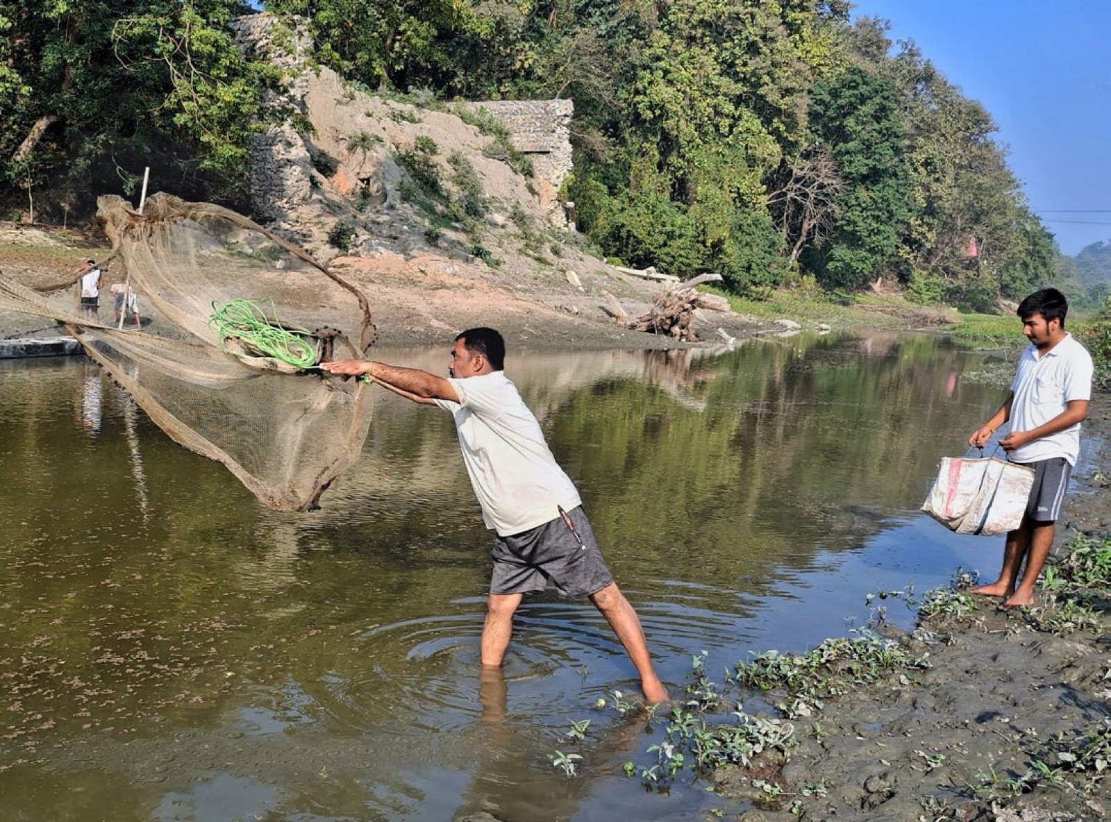 Pêcheur lançant un filet épervier dans une eau stagnante