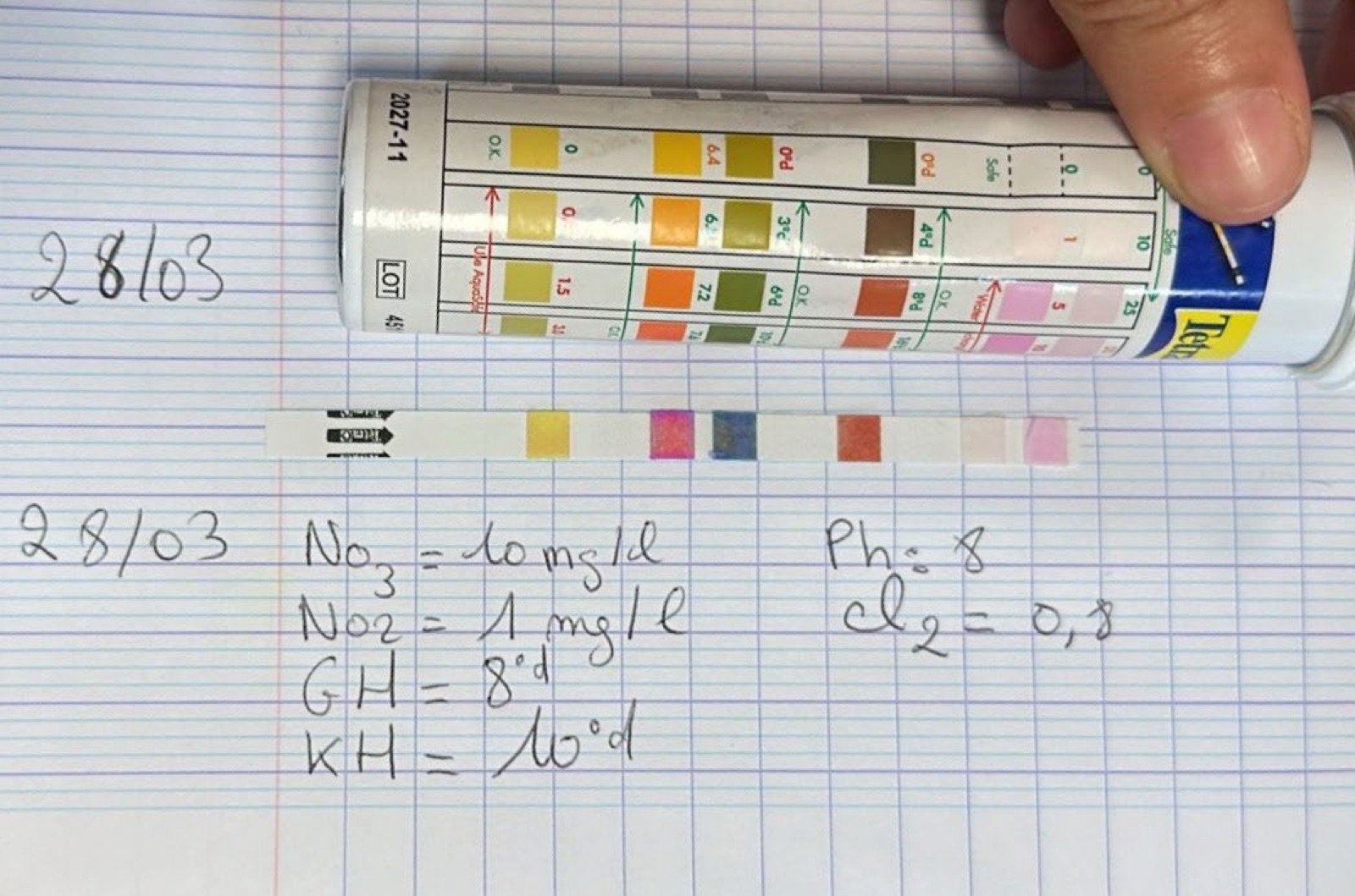 Test de qualité de l’eau d’un aquarium de classe et relevé des valeurs sur un cahier