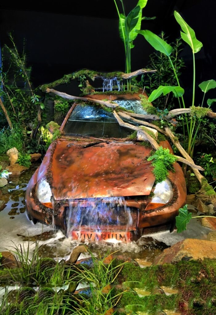 Décor de voiture rouillée envahie par la végétation au salon Vivarium 2025